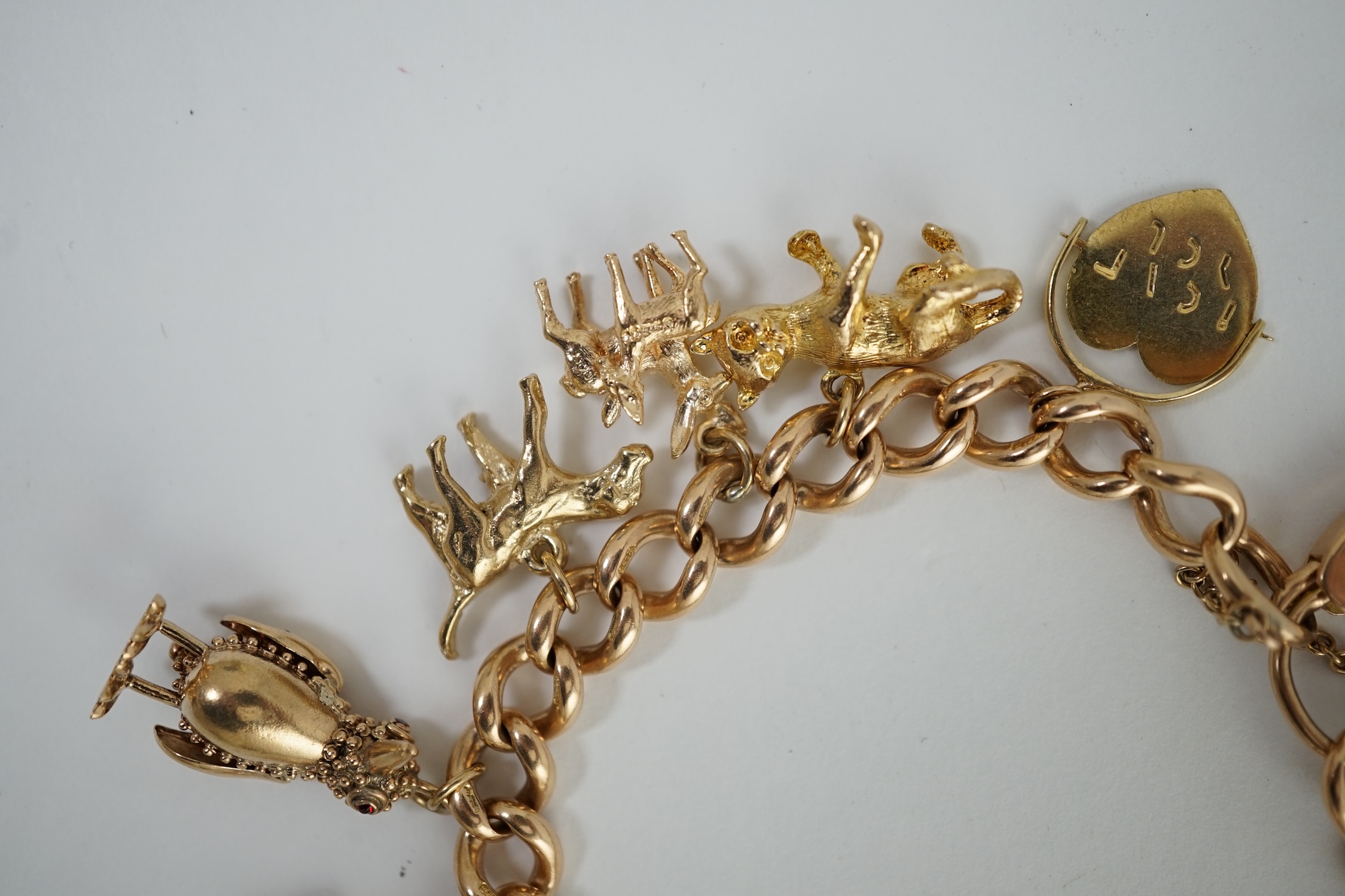 An early 20th century 15ct gold curb link charm bracelet